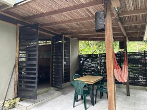 a patio with a table and chairs under a pergola at Cahuitas red frog house in Talamanca