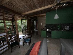 a living room with a couch and a kitchen at Cahuitas red frog house in Talamanca +5 photos