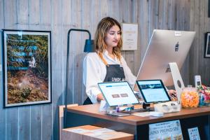 a woman standing at a desk with two computers at UNPLAN Kagurazaka in Tokyo