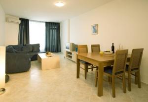 a living room with a table and chairs and a couch at Sunset Complex in Kosharitsa