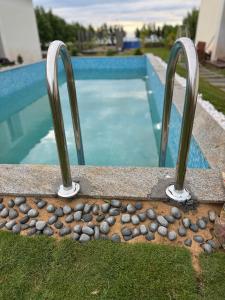 拉米斯瓦拉姆Road House Resort的游泳池旁带两个金属栏杆的游泳池