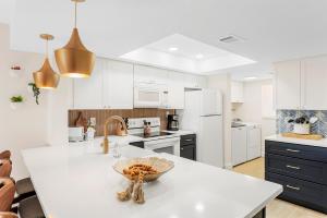 a kitchen with white cabinets and a bowl on a counter at Spanish Main - Cocoa Beach Oceanfront Condos near Port Canaveral in Cocoa Beach