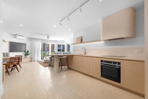 una cucina aperta con mobili in legno e una sala da pranzo di Serenity Apartments Noosa a Noosa Heads