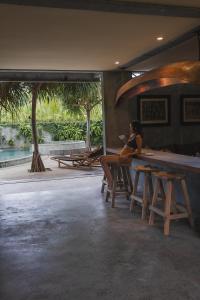 班尤温当Mangroove Bay Boutique Hostel的坐在酒吧桌子上的女人