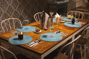 a wooden table with blue plates and silverware on it at Villas Edenia - Luxe Villas with Private Pools in Gili Trawangan +146 photos