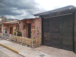 a house with a large wooden door on a street at Fully furnished 1bedroom apt in the Peruvian Andes in Sangarará