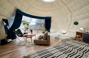 ein Schlafzimmer mit einem Bett, einem Schreibtisch und einem Stuhl in der Unterkunft Glampseason in Sendai