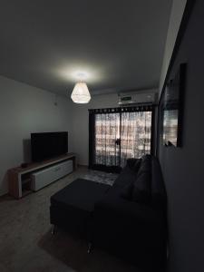 een woonkamer met een bank en een flatscreen-tv bij Antherina in San Luis