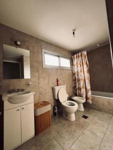 een badkamer met toilet, wastafel en bad bij Antherina in San Luis