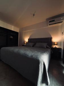 een slaapkamer met een groot bed met 2 lampen erop bij Antherina in San Luis