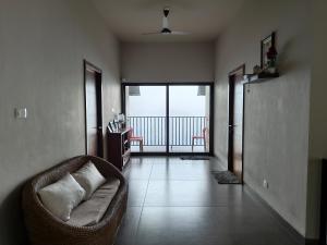 a living room with a couch and a balcony at Windy Cove by bukroom in Pīrmed