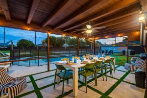 a dining room with a table and chairs on a patio at Your own 5BR Private Oasis! wPrivate PoolPickleball in West Palm Beach +41 photos