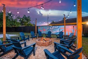 a patio with blue chairs around a fire pit at Your own 5BR Private Oasis! wPrivate PoolPickleball in West Palm Beach