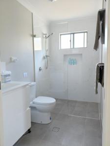 a white bathroom with a toilet and a shower at Ella Cottage - Relaxing romantic escape-Southern Highlands  +39 photos