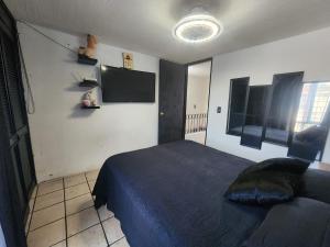 a bedroom with a bed and a flat screen tv at Casa entera, elegante, moderna in Guadalajara