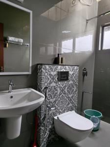 a white bathroom with a sink and a toilet at Windy Cove by bukroom in Pīrmed