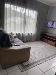 ein Wohnzimmer mit Couch und großem Fenster in der Unterkunft Lugar pra relaxar...Perto de tudo .. in Búzios