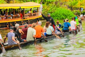 eine Gruppe von Menschen in einem Boot auf dem Wasser in der Unterkunft Oyster Homes in Munroe Island