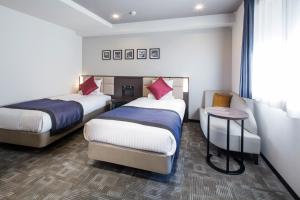 Rúm í herbergi á HOTEL MYSTAYS Kanda
