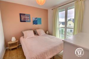 a bedroom with a bed and a large window at St christophe in Lézardrieux