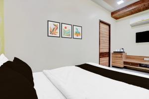 艾哈迈达巴德Super Hotel O Naroda GIDC Formerly Yuvraj的卧室里有一张白色的床和一台电视