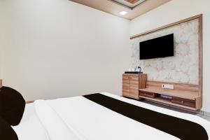 艾哈迈达巴德Super Hotel O Naroda GIDC Formerly Yuvraj的一间卧室，里面有一张床和一台平板电视