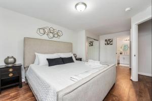 a bedroom with a large white bed and a wooden floor at Luxury Villa Paradise Home in Honokai Hale
