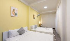 Villas VÕ THỊ SÁU Bãi Sau Xinh في فنغ تاو: سريرين في غرفة بجدران صفراء +12 صورة