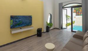 Villas VÕ THỊ SÁU Bãi Sau Xinh في فنغ تاو: غرفة معيشة مع أريكة وتلفزيون بشاشة مسطحة