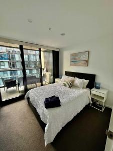 Un dormitorio con una cama grande y un balcón. en City-Self check in-Parking-Pool, en Canberra