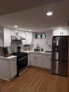 a kitchen with white cabinets and stainless steel appliances at Janets Cove in Medford
