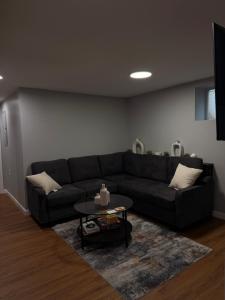 a living room with a black couch and a table at Janets Cove in Medford