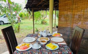 una mesa con platos y tazones de fruta. en DNA secret palace, en Tangalle 14 fotos más