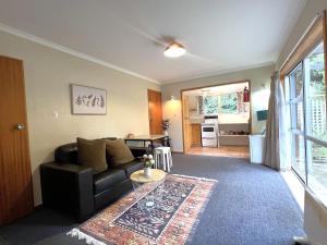 een woonkamer met een bank en een tafel bij Mt Aspiring Home in Wanaka