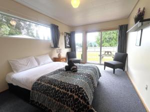 een slaapkamer met een bed en een groot raam bij Mt Aspiring Home in Wanaka +21 foto's