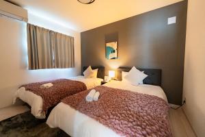 two beds in a hotel room with two beds at Villa Nuunu in Miyako-jima