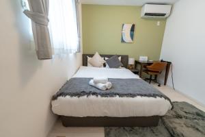 a bedroom with a bed with a teddy bear on it at Villa Nuunu in Miyako-jima
