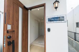 a door to a hallway with a sign that reads white murmur at Villa Nuunu in Miyako-jima