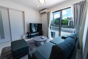 a living room with a blue couch and a tv at Villa Nuunu in Miyako-jima +33 photos