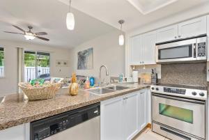 a kitchen with white cabinets and a counter top at Hawaiian Dream Villa 1 mile from Disney Aulani in Honokai Hale