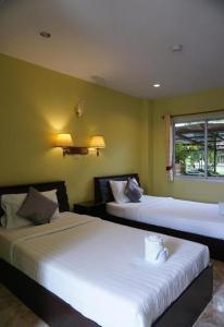 twee bedden in een kamer met groene muren bij Phoem Phoon 2 Hotel in Nan