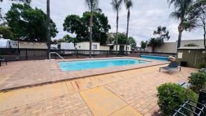 a swimming pool in a yard with a chair next to it at Griffith Tourist Caravan park in Griffith