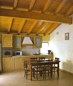 eine Küche mit einem Tisch und Stühlen im Zimmer in der Unterkunft Agriturismo Il Sorriso dei Figli in Argegno