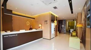 a lobby of a building with a woman sitting at a counter at IU Hotel Zhengzhou Xinzheng Sias International University Branch in Xinzhengzhan