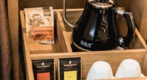 a wooden drawer with a tea kettle and other items at James Joyce Coffetel Baoding Railway Station in Baoding