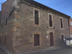 een stenen gebouw waar een man voor staat bij Casa Rural El Zumaque in Pereña