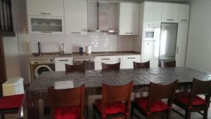 a kitchen with a table and chairs and a refrigerator at Casa Rural El Zumaque in Pereña +3 photos