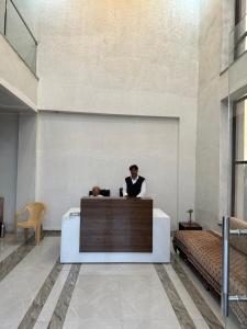 a man standing at a reception desk in a lobby at ENERGY Inn in Kotri Kalān