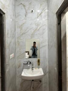 a man taking a picture of a bathroom mirror at ENERGY Inn in Kotri Kalān +22 photos
