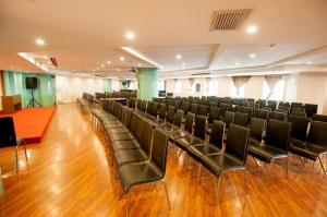 a large room with black chairs and a stage at City Comfort Inn Wuhan Ikea in Wuhan
